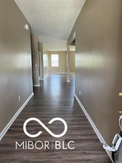 hallway featuring dark hardwood / wood-style floors and lofted ceiling