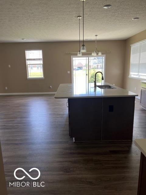 kitchen featuring a center island with sink, plenty of natural light, hanging light fixtures, and sink