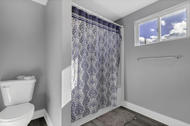 bathroom with wood-type flooring, toilet, and shower / bath combination with curtain