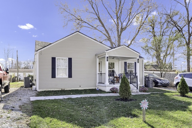 view of front of home with covered porch, central air condition unit, and a front lawn