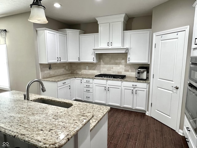 kitchen with white cabinets, sink, and an island with sink