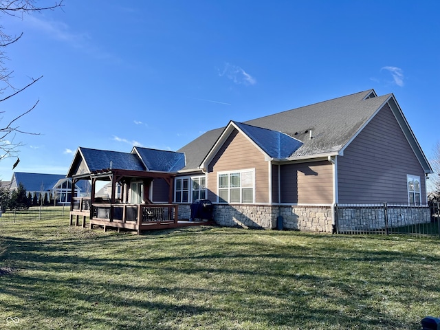 rear view of property with a lawn and a deck