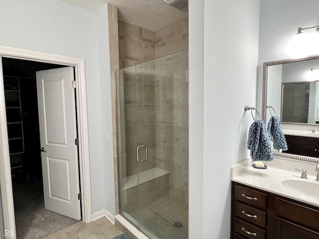 bathroom with tile patterned floors, vanity, and walk in shower