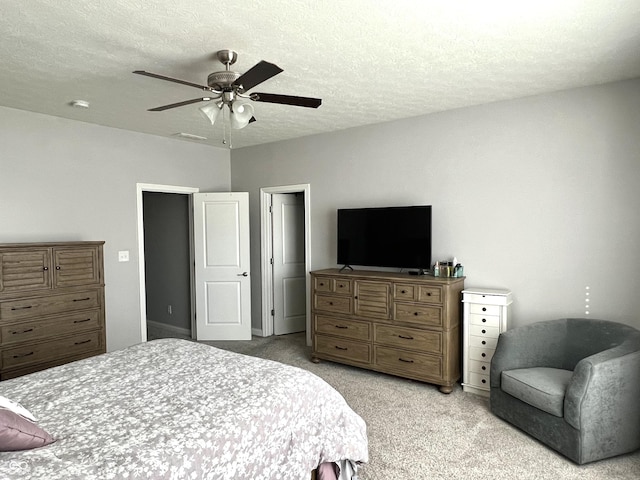 carpeted bedroom with ceiling fan and a textured ceiling