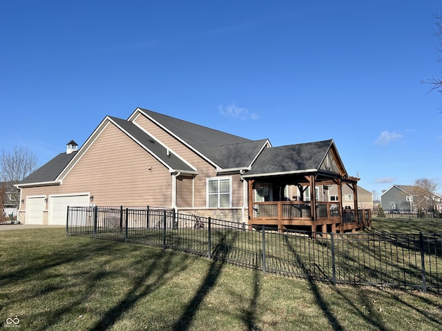 view of side of home featuring a yard, a garage, and a deck