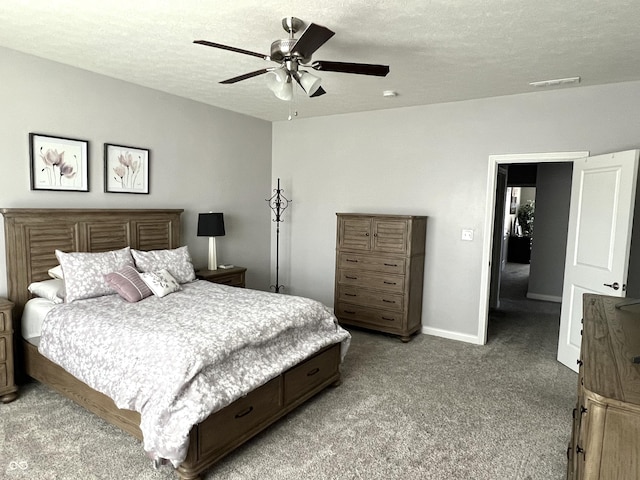 bedroom featuring ceiling fan, light colored carpet, and a textured ceiling