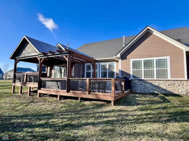 back of house featuring a pergola, a wooden deck, and a lawn