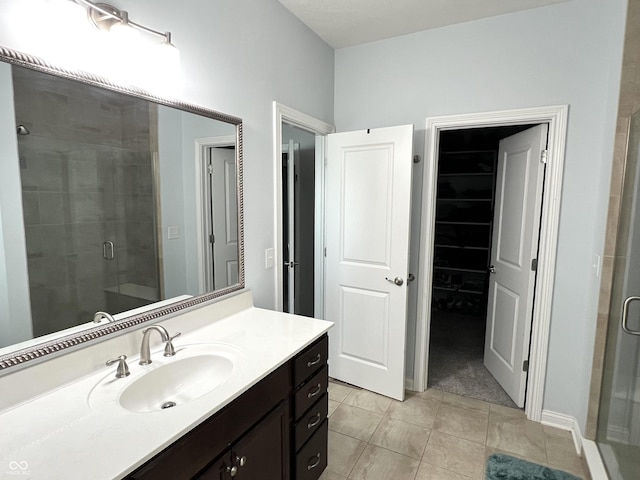 bathroom with tile patterned flooring, vanity, and walk in shower