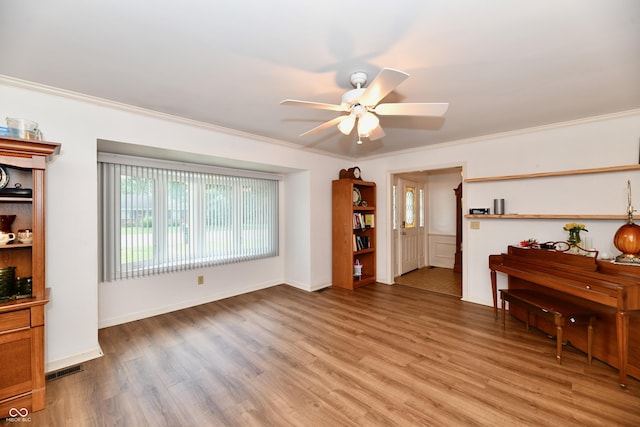 living room featuring light hardwood / wood-style floors, ceiling fan, and crown molding