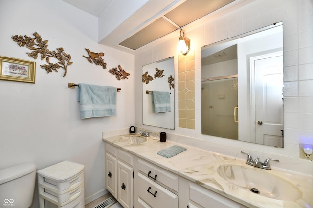 bathroom featuring vanity, toilet, and a shower with shower door