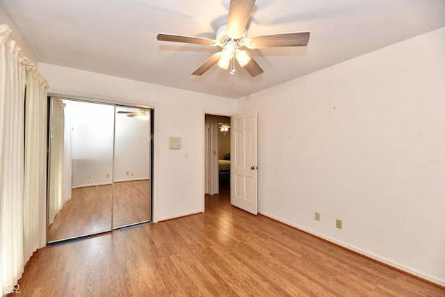 unfurnished bedroom with a closet, light hardwood / wood-style flooring, and ceiling fan