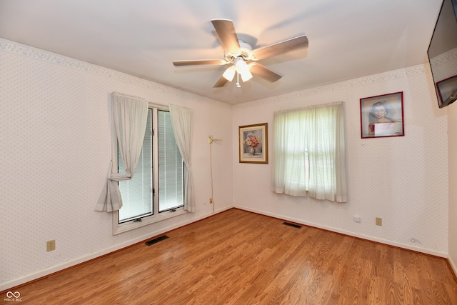 spare room with plenty of natural light, light hardwood / wood-style floors, and ceiling fan