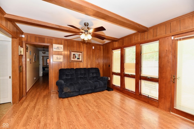 living room with ceiling fan, beam ceiling, and light hardwood / wood-style flooring