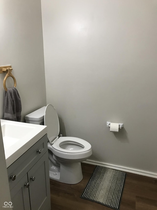 bathroom with hardwood / wood-style floors, vanity, and toilet