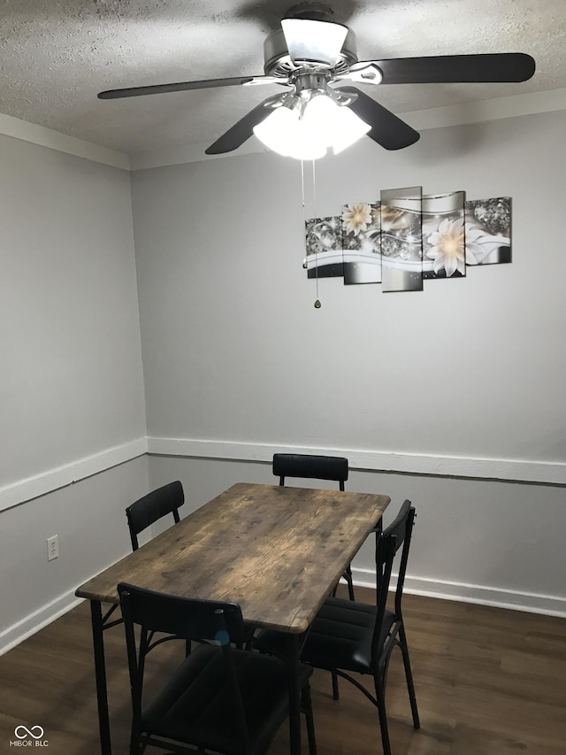 dining space with dark hardwood / wood-style flooring and a textured ceiling