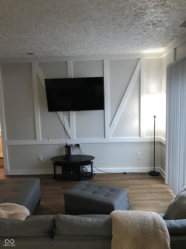 living room with wood-type flooring and a textured ceiling