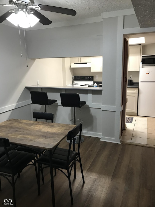 dining space with dark hardwood / wood-style flooring and ceiling fan