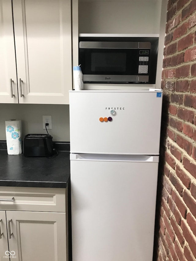 room details with white cabinetry and white fridge