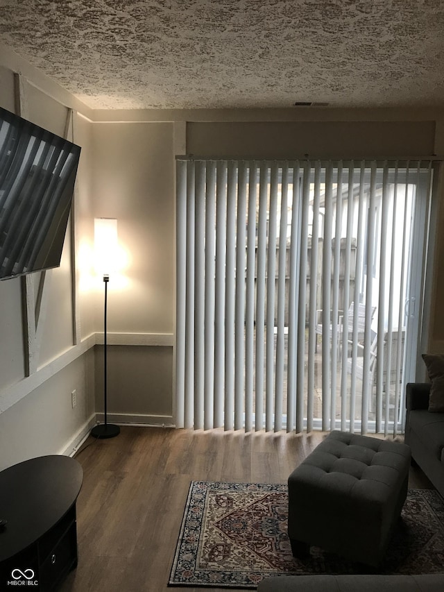 sitting room with wood-type flooring and a textured ceiling