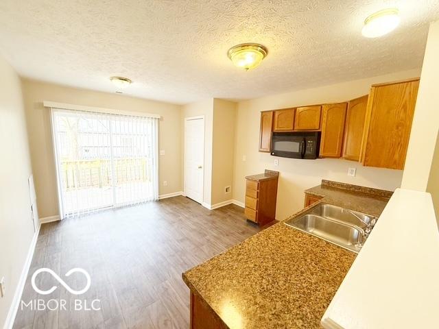 kitchen with wood-type flooring, a textured ceiling, and sink