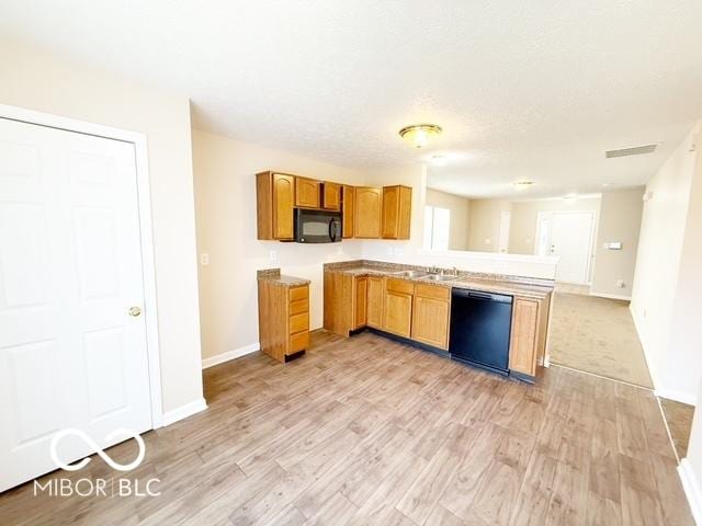 kitchen featuring kitchen peninsula, sink, light hardwood / wood-style flooring, and black appliances