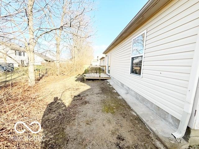 view of property exterior with a wooden deck