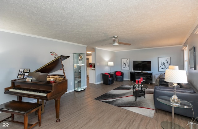 living room featuring ceiling fan, hardwood / wood-style flooring, a textured ceiling, and ornamental molding