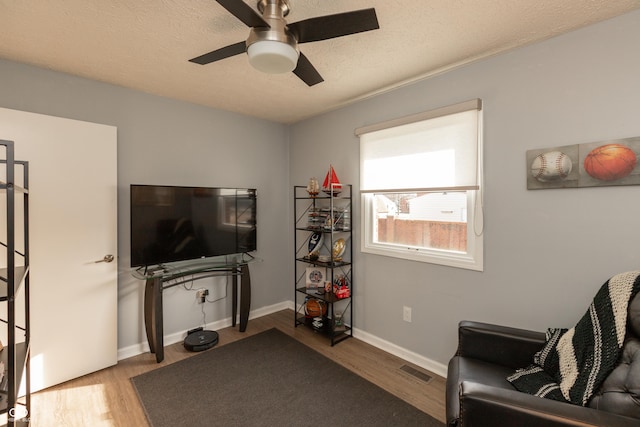 sitting room with hardwood / wood-style floors and ceiling fan