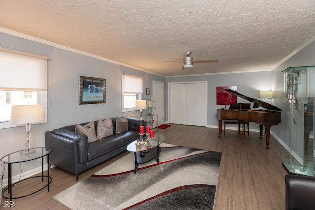 living room featuring wood-type flooring, ceiling fan, and ornamental molding