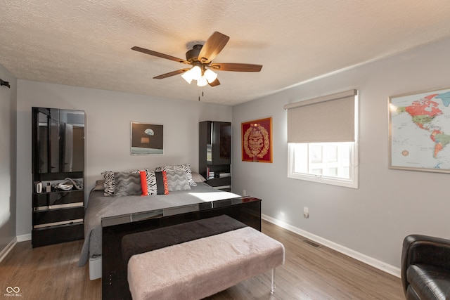 interior space with a textured ceiling, ceiling fan, and dark wood-type flooring