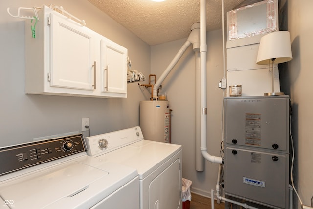 laundry room featuring cabinets, a textured ceiling, washing machine and clothes dryer, and water heater