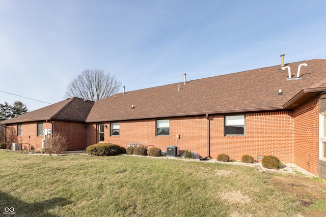 rear view of house featuring a lawn and central AC unit