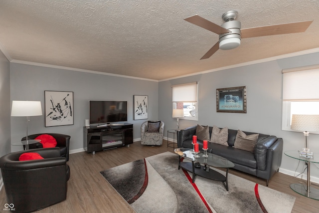 living room featuring ceiling fan, a healthy amount of sunlight, dark hardwood / wood-style floors, and ornamental molding