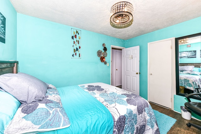 bedroom with dark hardwood / wood-style flooring and a textured ceiling