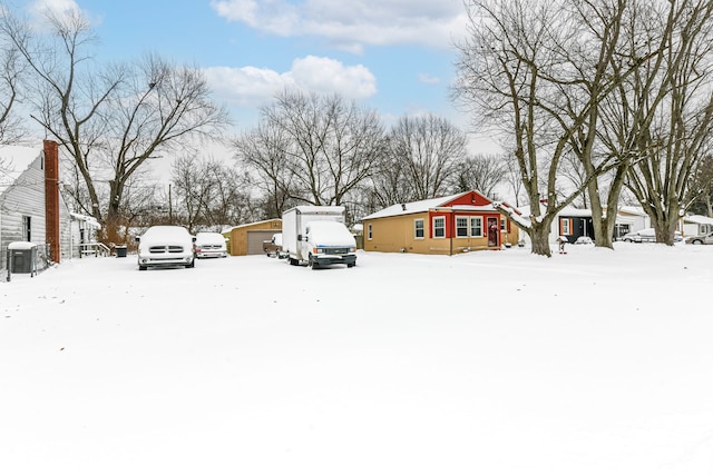 yard covered in snow featuring a garage and an outbuilding