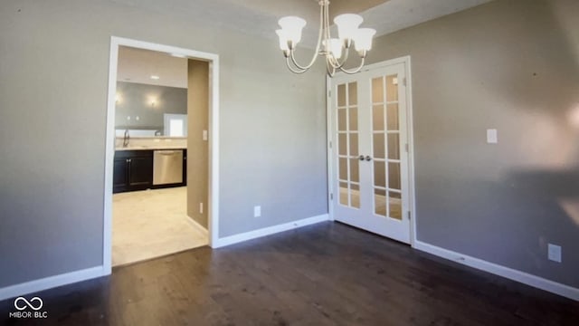 unfurnished dining area featuring french doors, dark hardwood / wood-style floors, an inviting chandelier, and sink