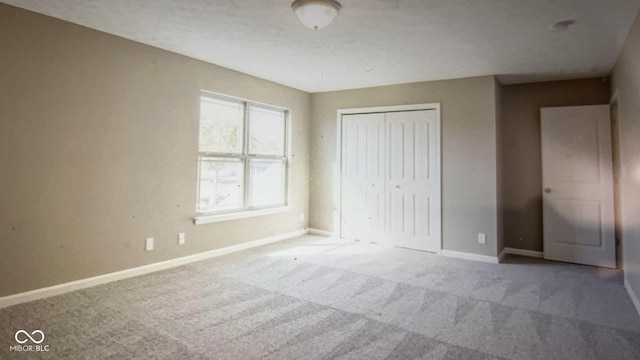 unfurnished bedroom with carpet flooring and a closet