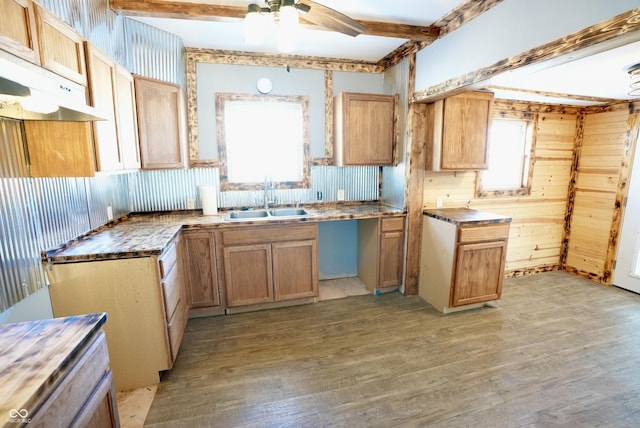 kitchen with light wood-type flooring, beamed ceiling, ceiling fan, decorative backsplash, and sink