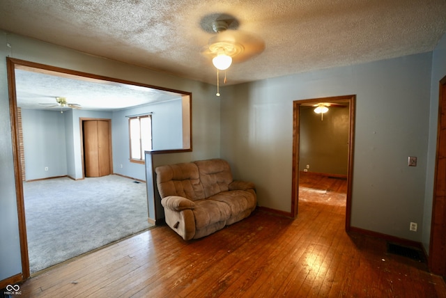 living area featuring a textured ceiling and hardwood / wood-style flooring