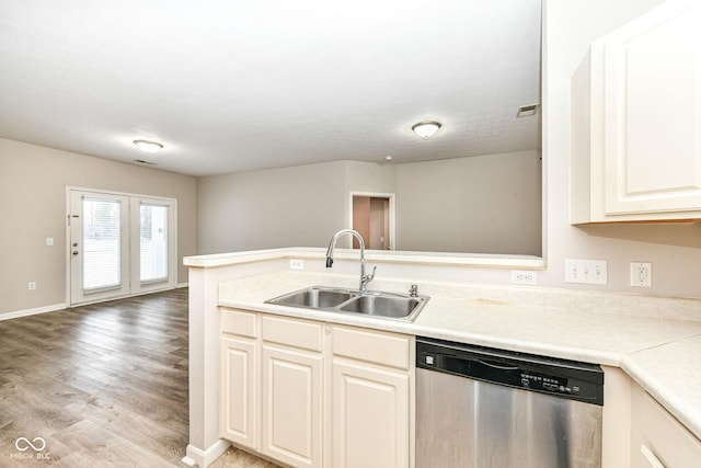 kitchen with kitchen peninsula, light hardwood / wood-style flooring, stainless steel dishwasher, and sink