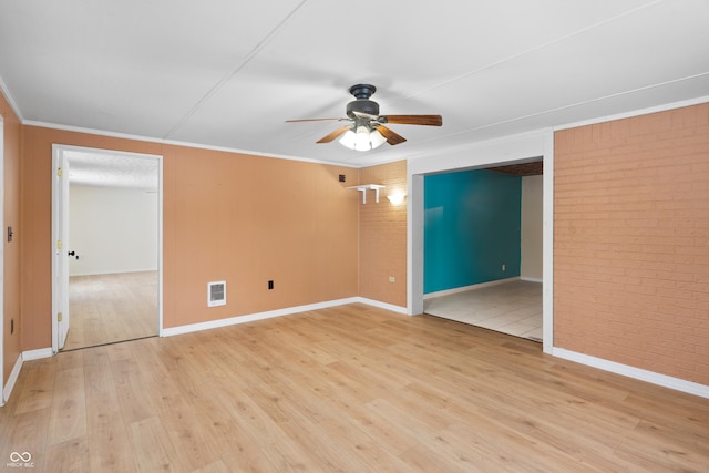 unfurnished room featuring ceiling fan, light hardwood / wood-style floors, crown molding, and brick wall