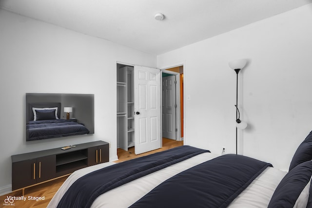 bedroom with hardwood / wood-style floors and a closet