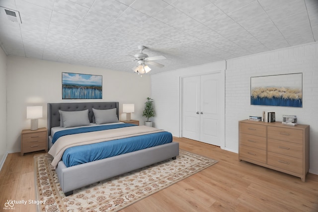 bedroom featuring ceiling fan, light wood-type flooring, and a closet