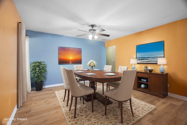 dining space featuring a textured ceiling, light hardwood / wood-style floors, and ceiling fan