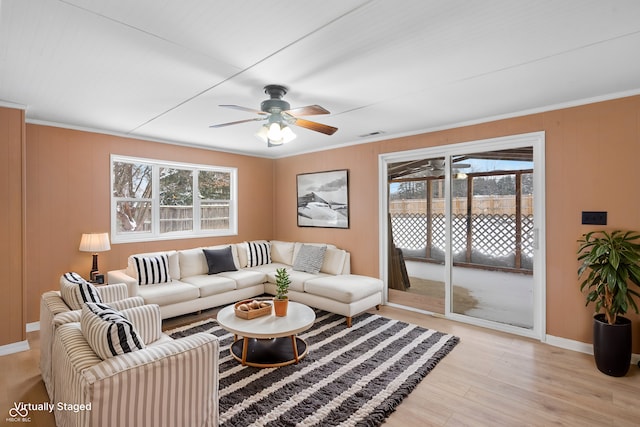 living room featuring crown molding, ceiling fan, and a healthy amount of sunlight