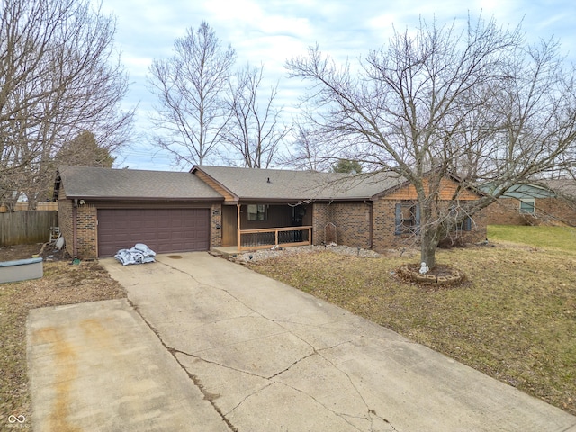 view of front facade with a porch, fence, concrete driveway, a garage, and brick siding