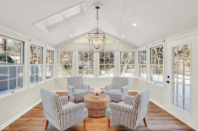 sunroom featuring vaulted ceiling and an inviting chandelier