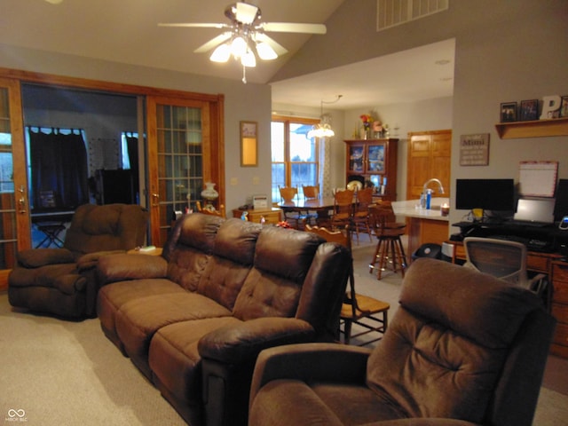 carpeted living room featuring vaulted ceiling and ceiling fan with notable chandelier