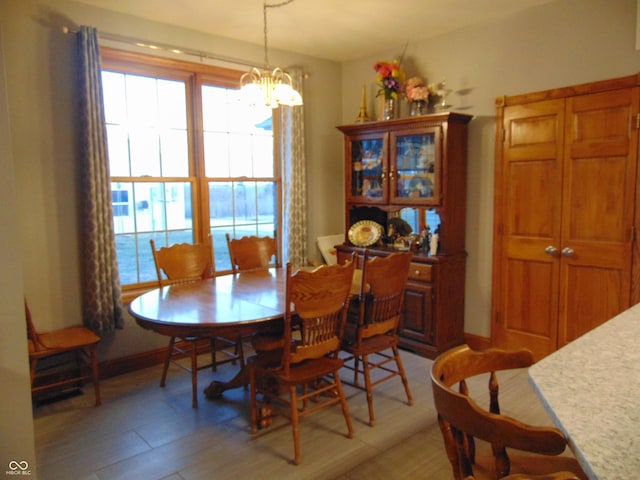 dining space featuring wood-type flooring and a notable chandelier