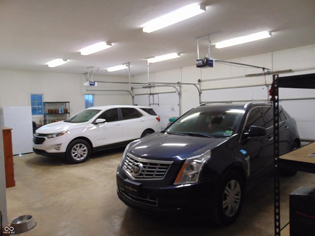 garage featuring white fridge and a garage door opener